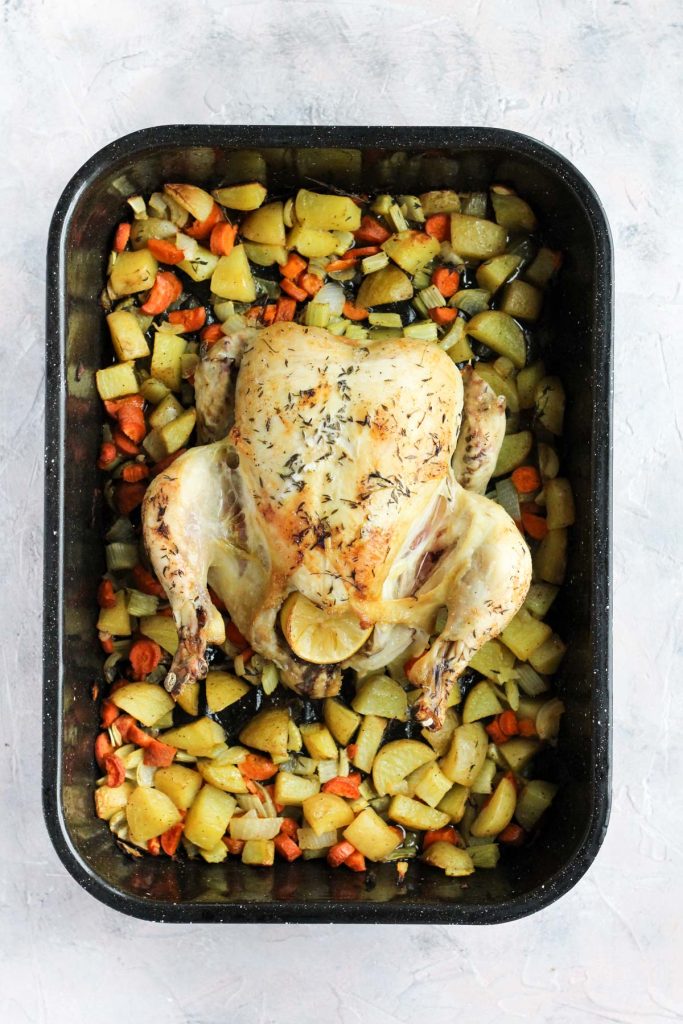 Baked chicken in pan with vegetables.