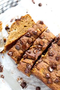 Side shot of pumpkin banana bread on parchment paper.
