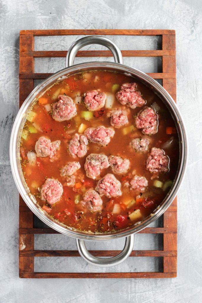 Raw meatballs in soup.