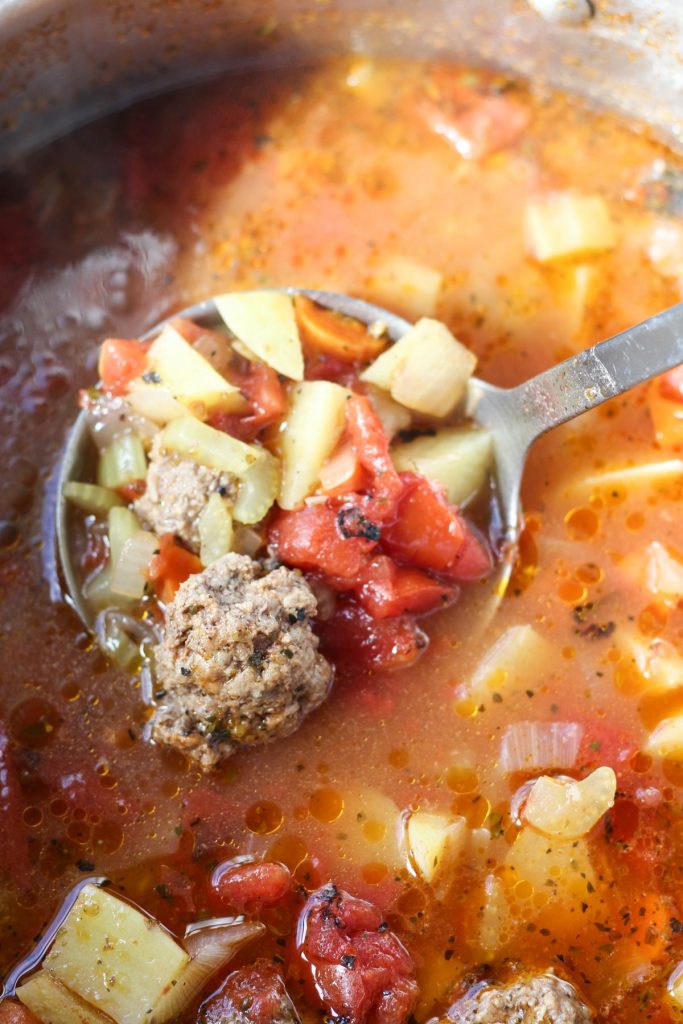 Scooping out soup from pot.
