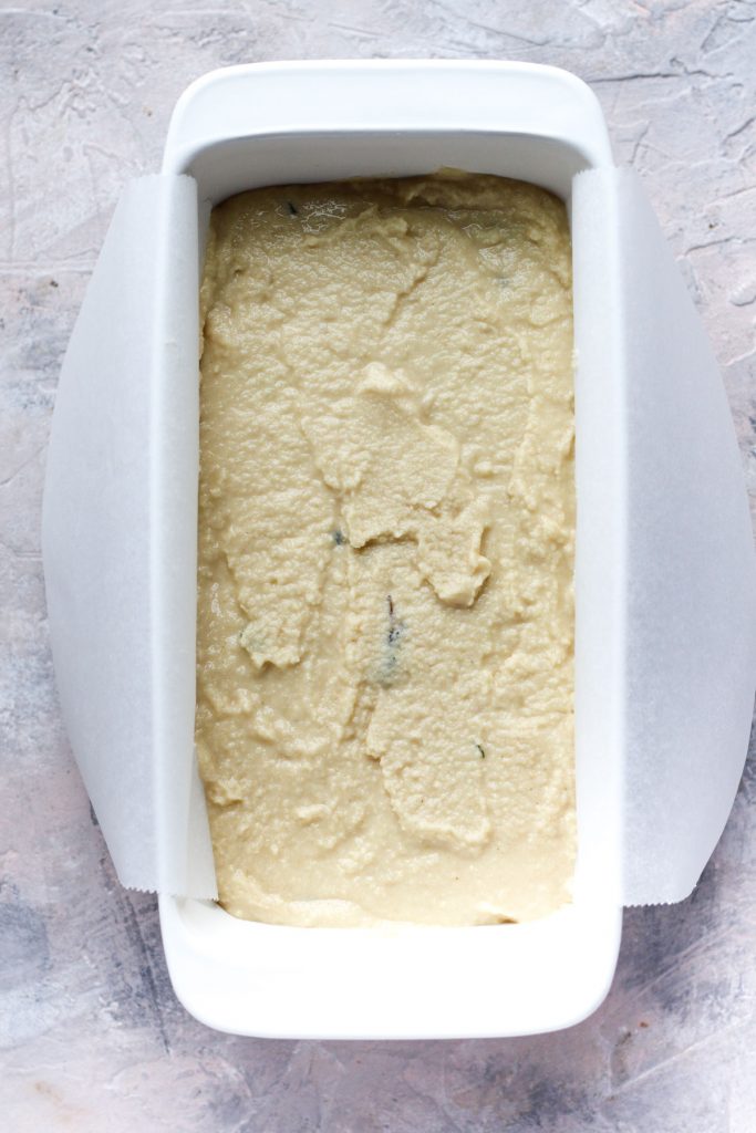 Bread dough in parchment paper lined bread pan.