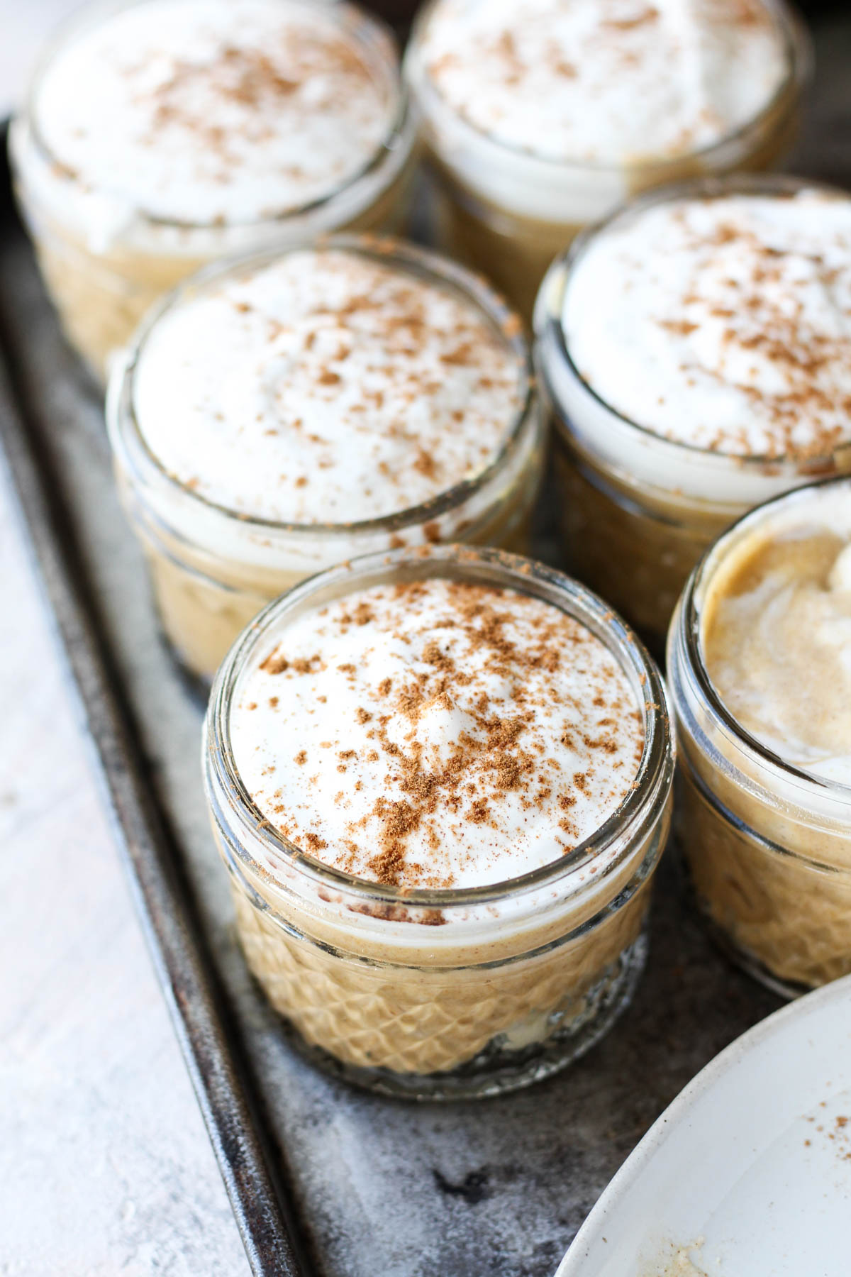 Pumpkin mousse cups lined up next to each other.