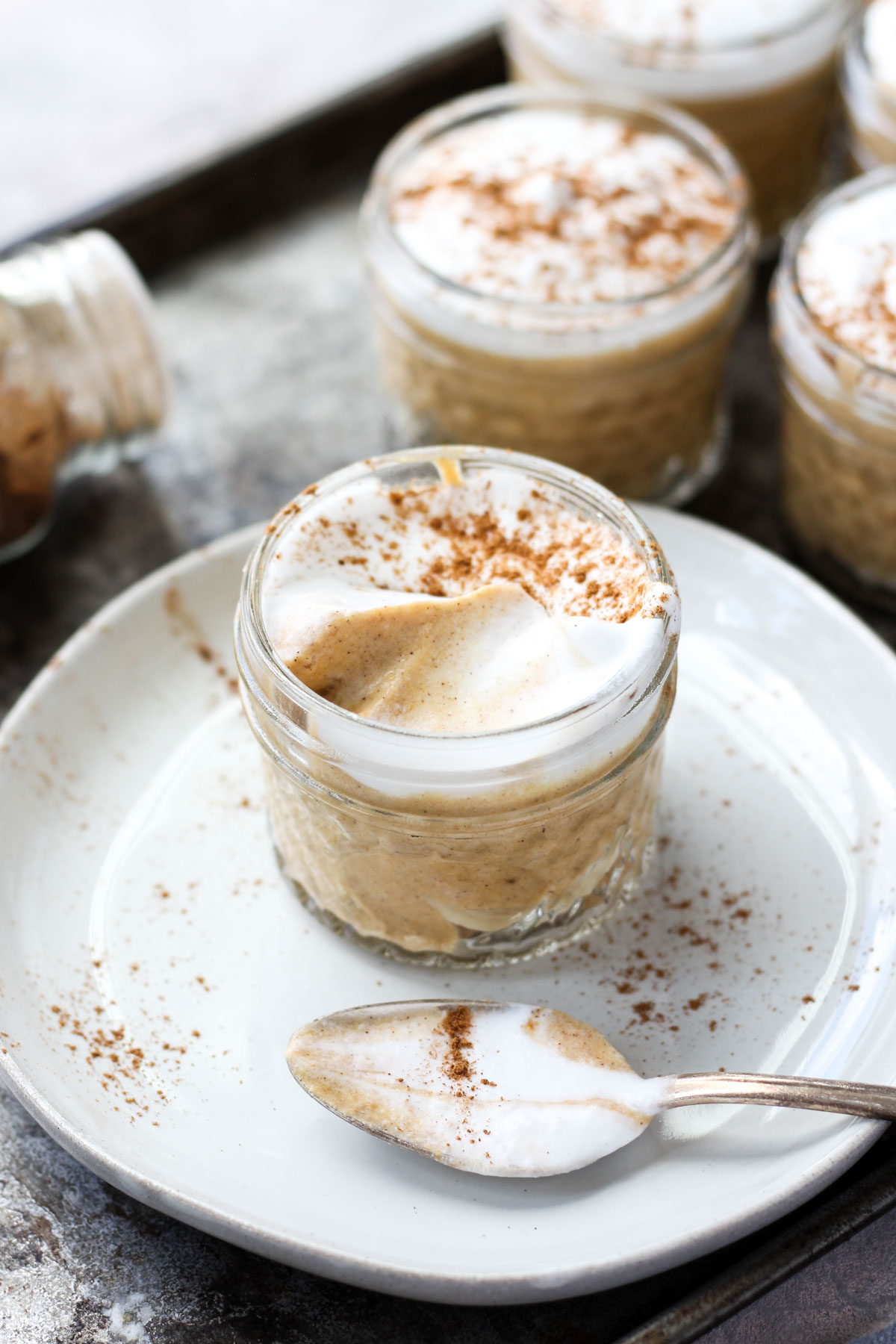 Cup of pumpkin mousse with a spoon on the side.