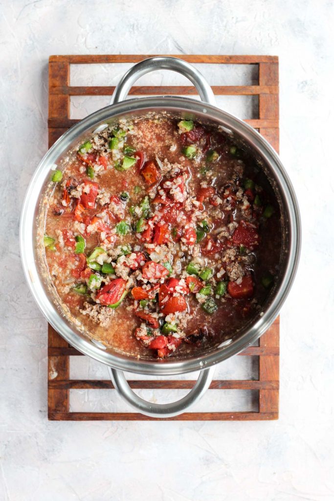 Vegetables and tomatoes in pot with meat.