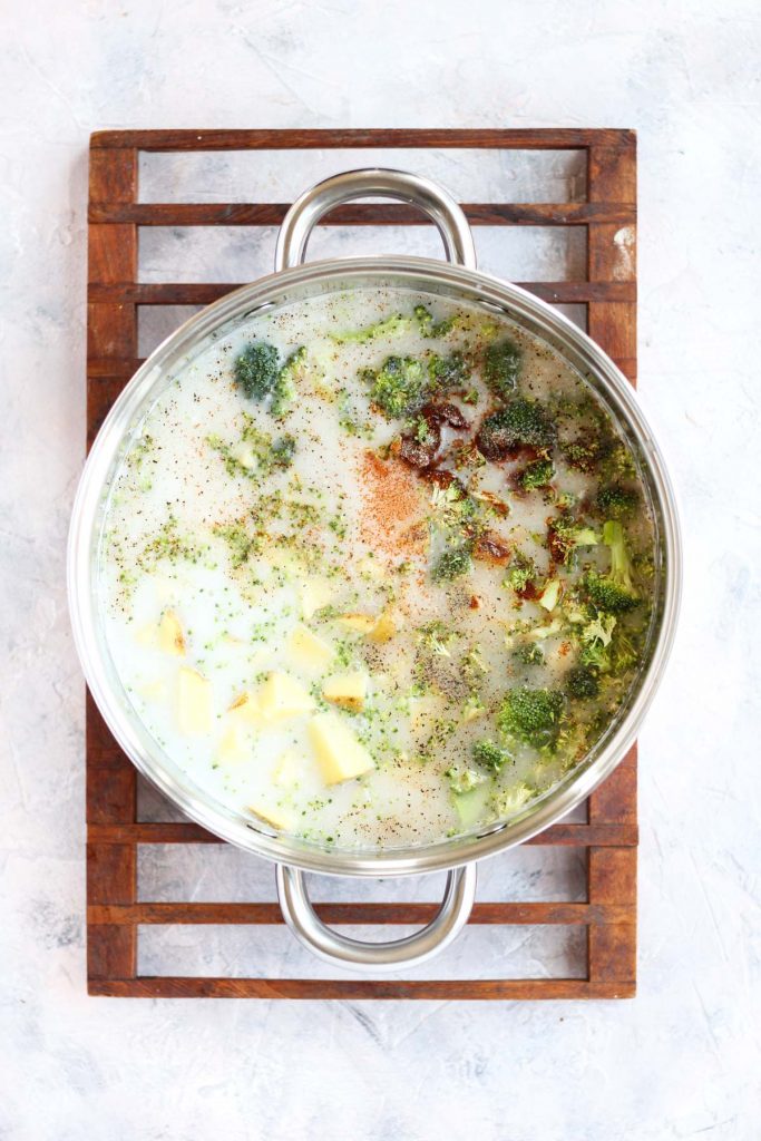Vegetables, broth, and spices in large pot.