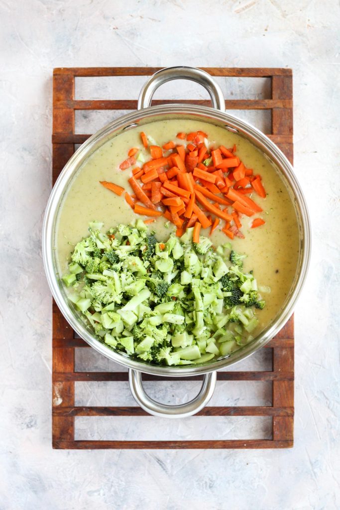 Broth with fresh broccoli and chopped carrots on top.