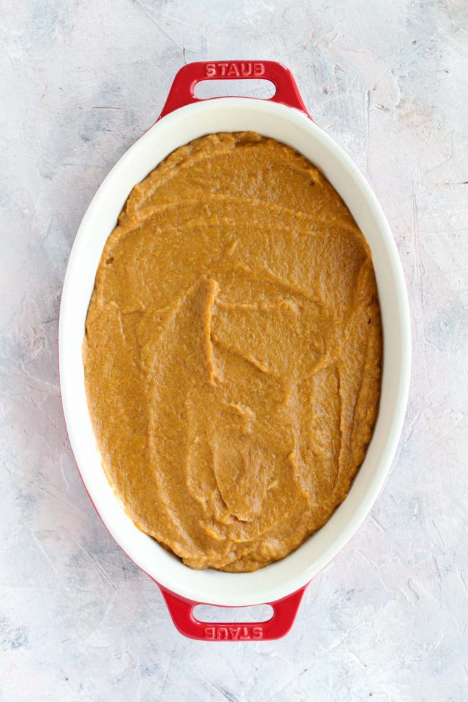 Casserole dish with bottom layer of sweet potato mash.