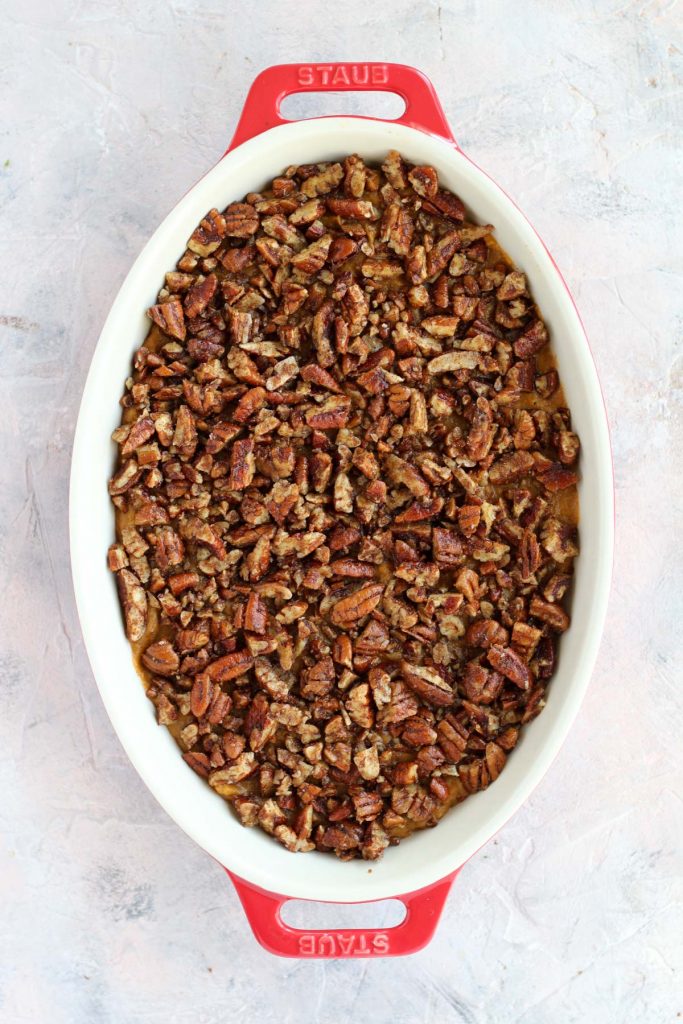 Candied pecans on top of sweet potato mash before going in the oven.