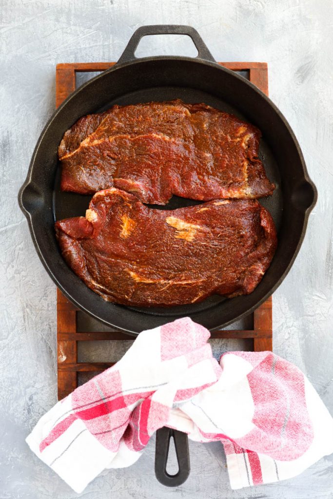 Steak in cast iron skillet.