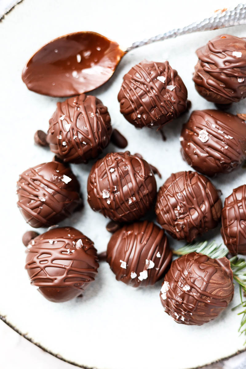 Overhead shot of chocolate peppermint truffles on a white plate.