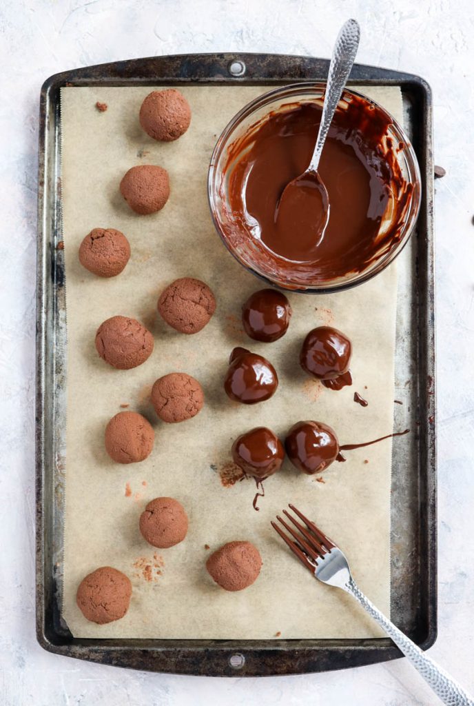 Truffles being dipped into chocolate.