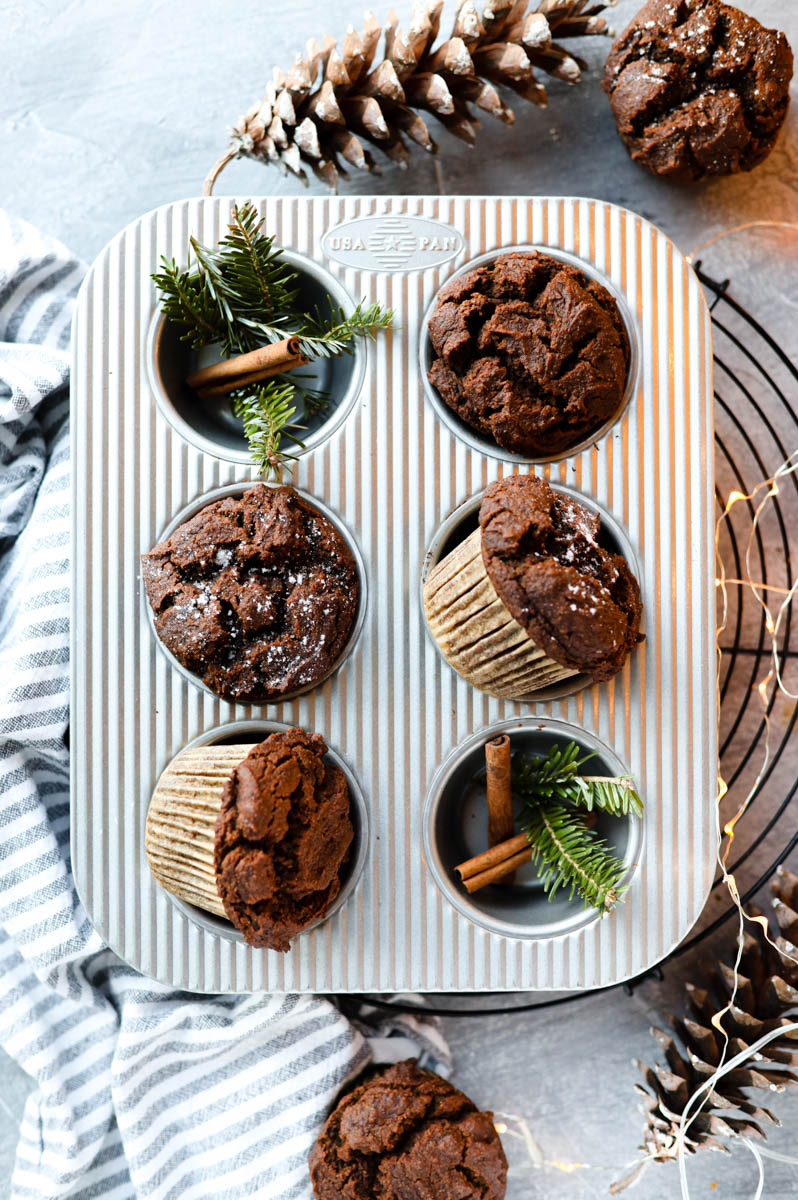 Muffins in muffin tin with powdered sugar on top.