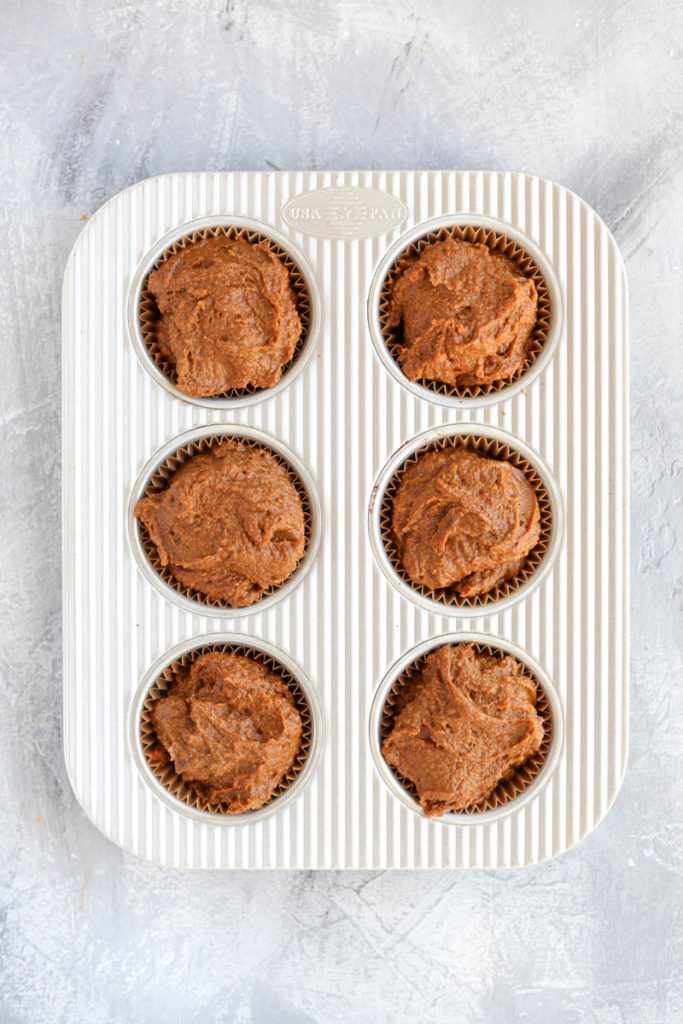 Muffin batter in muffin tins.