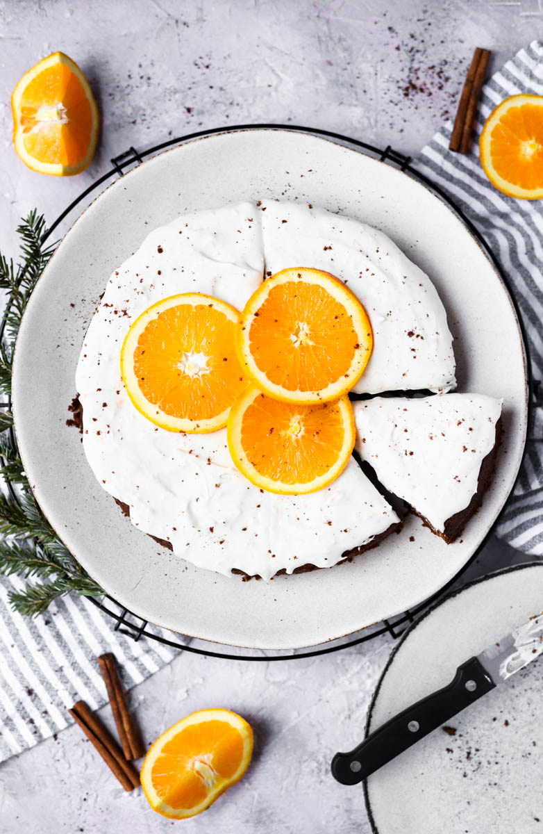 Overhead picture of gingerbread orange cake with orange slices on top.