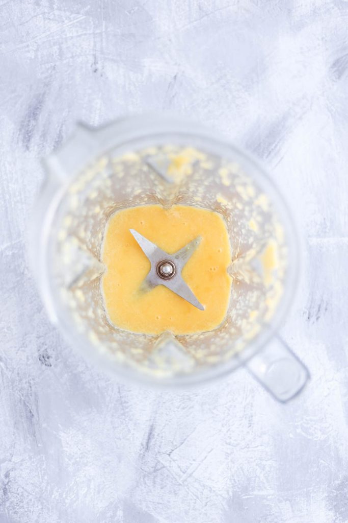 Overhead shot of orange puree in blender.