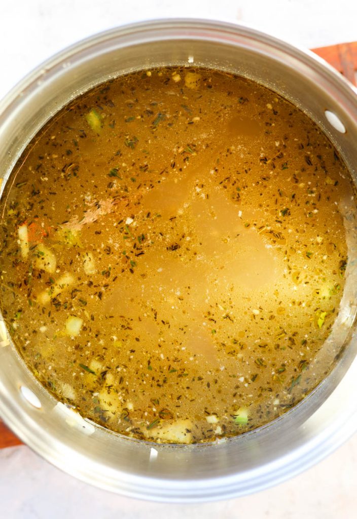 Bone broth and vegetables in large pot.