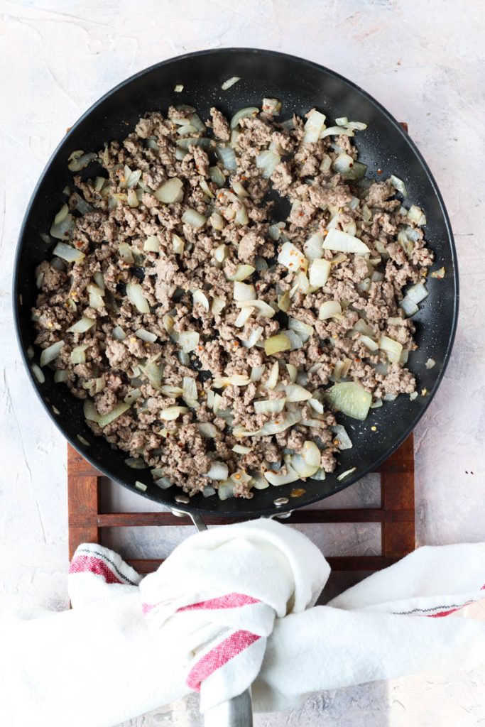 Ground beef and onions in pan.