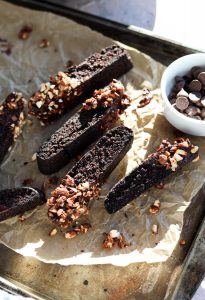 Chocolate biscotti on a baking sheet with parchment paper.