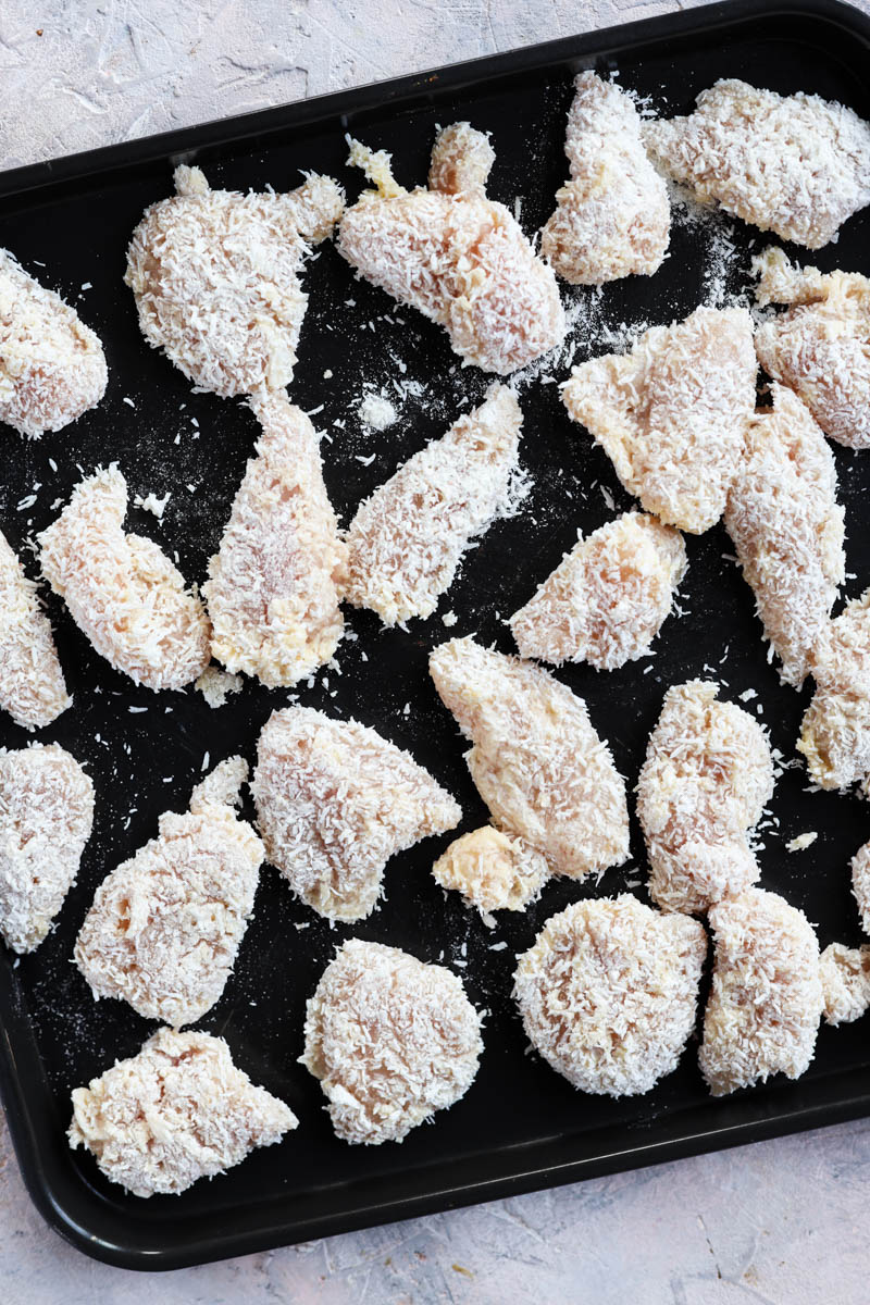 Breaded chicken on baking tray.