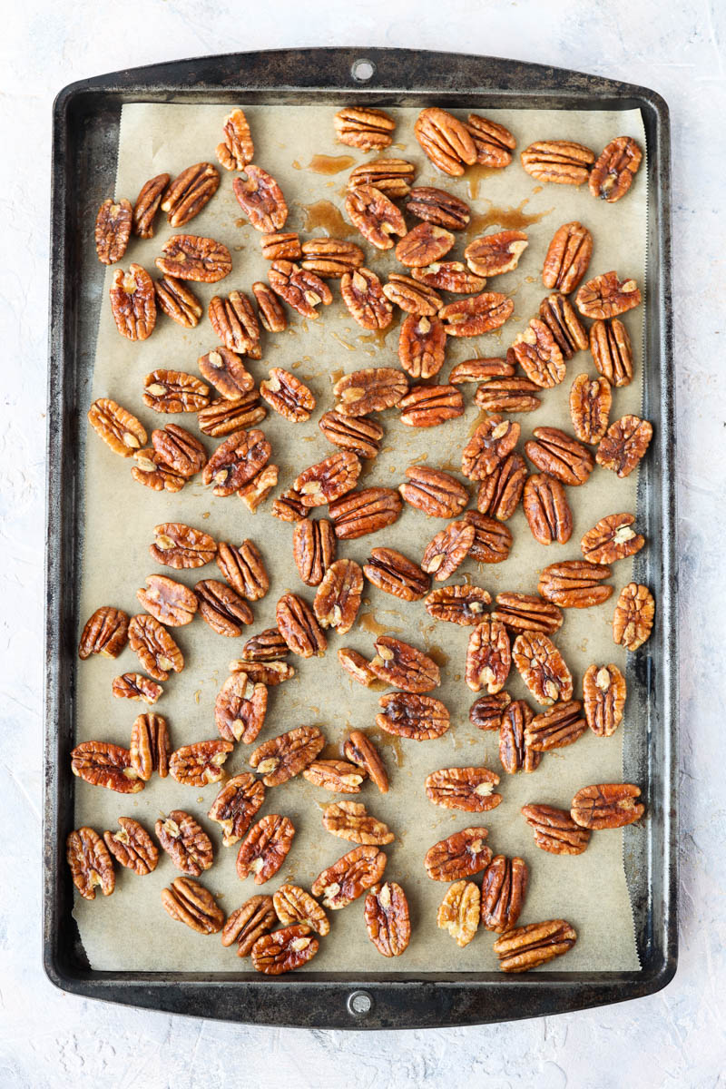 Pecans spread out on a baking sheet.