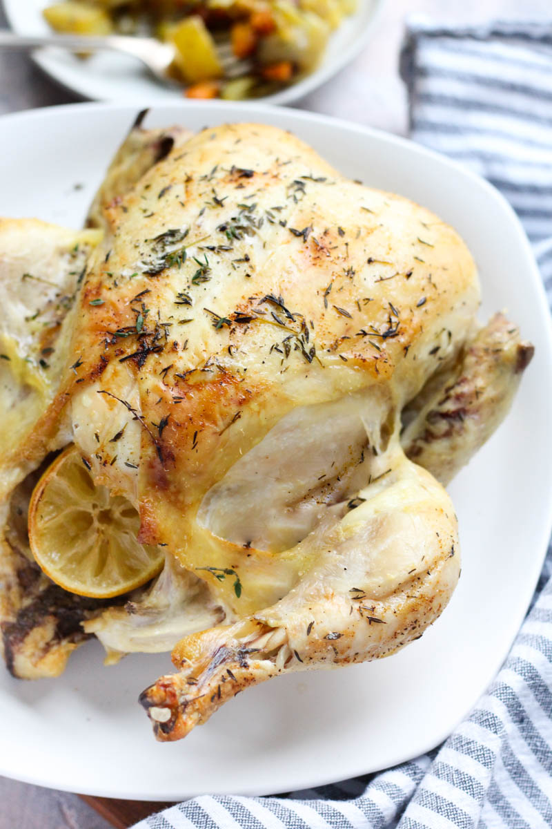 Side angle of crispy whole roasted chicken.