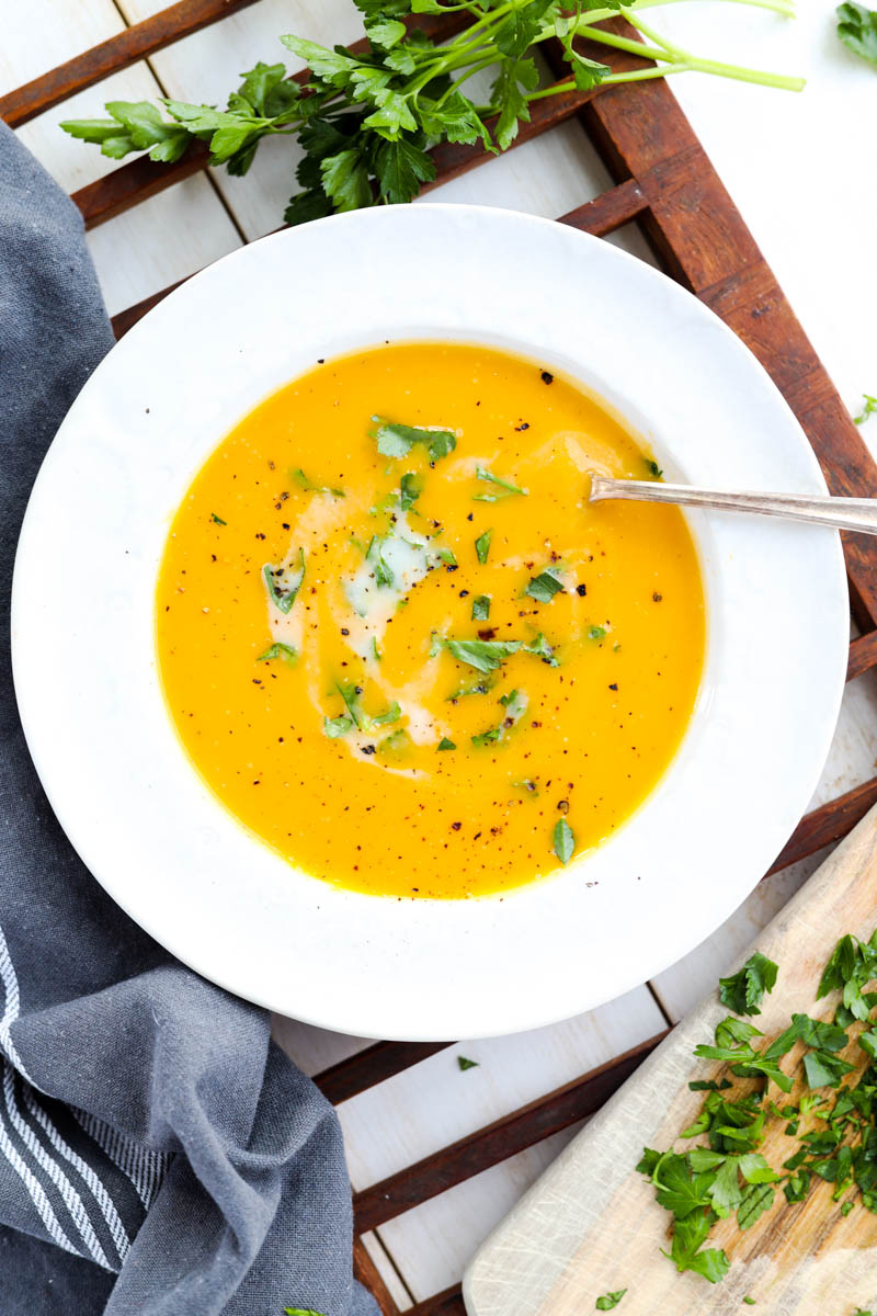 Bowl of butternut squash soup with fresh parsley on top.