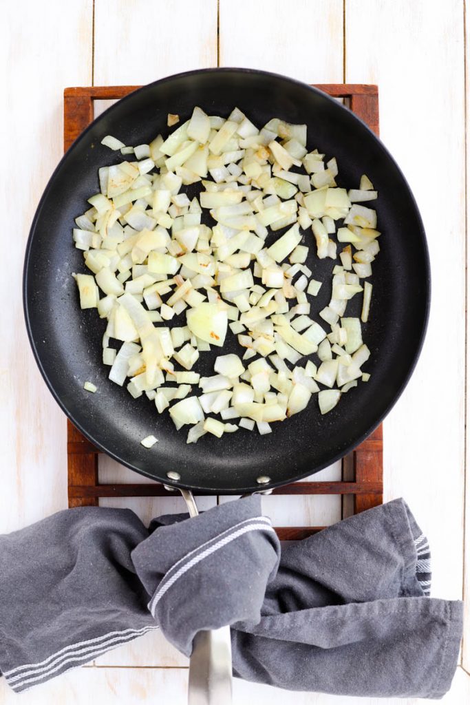 Onion cooking in frying pan.