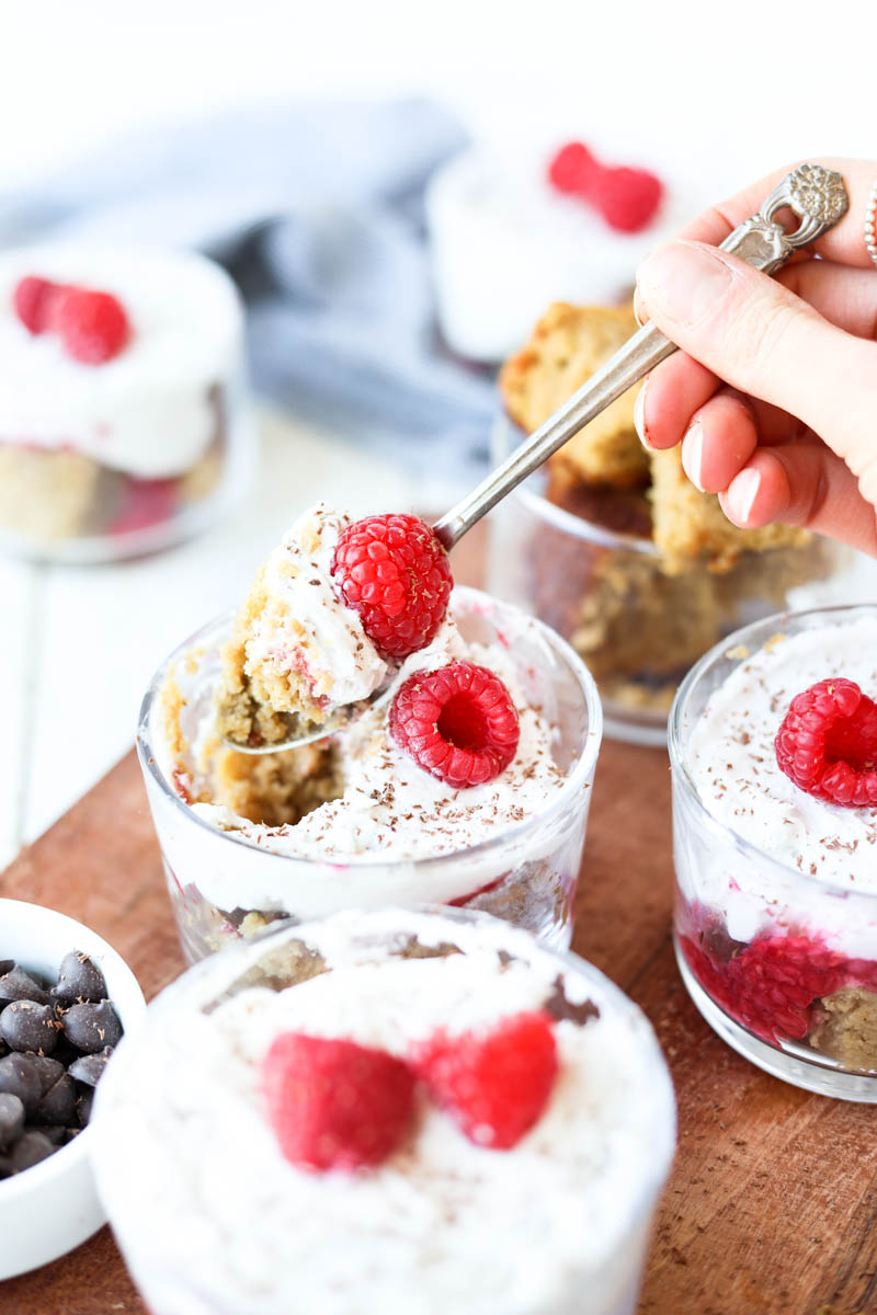 Spoon scooping out raspberry trifle cups.
