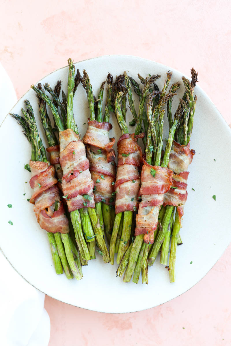 White plate with bacon wrapped asparagus.