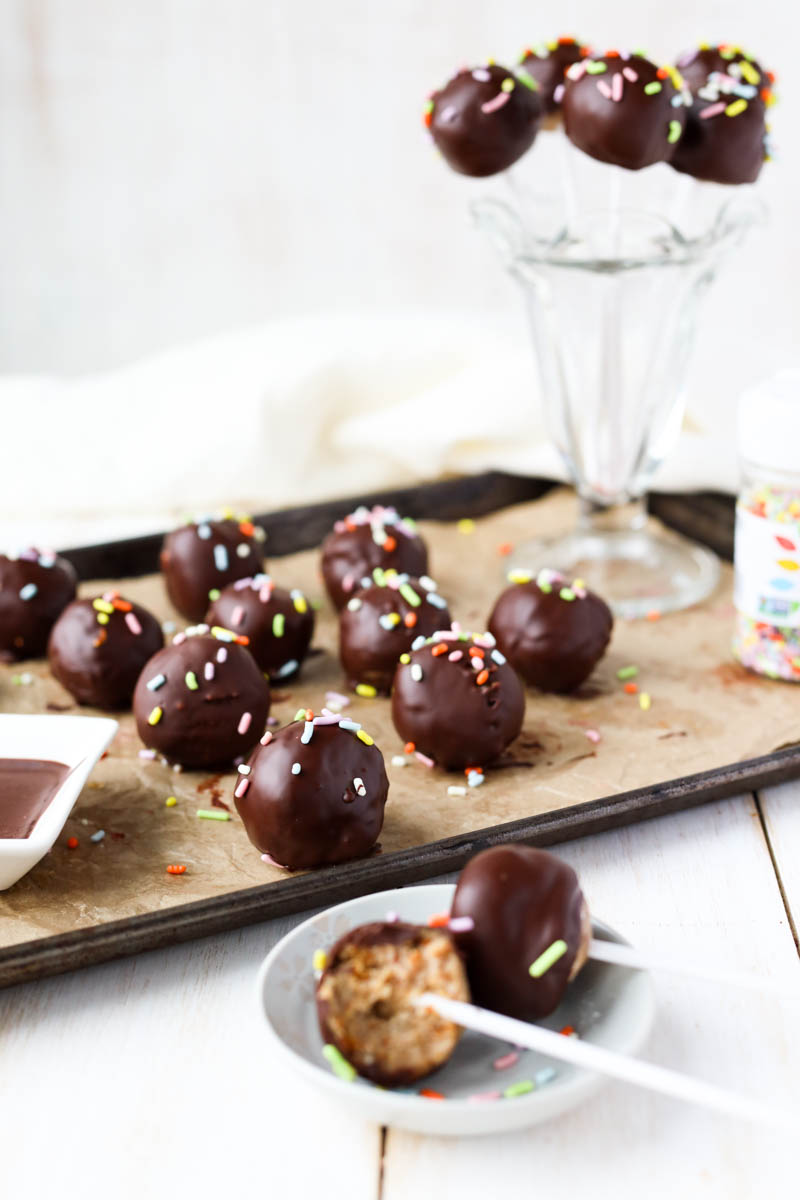 Cake pops on a parchment paper lined baking sheet.