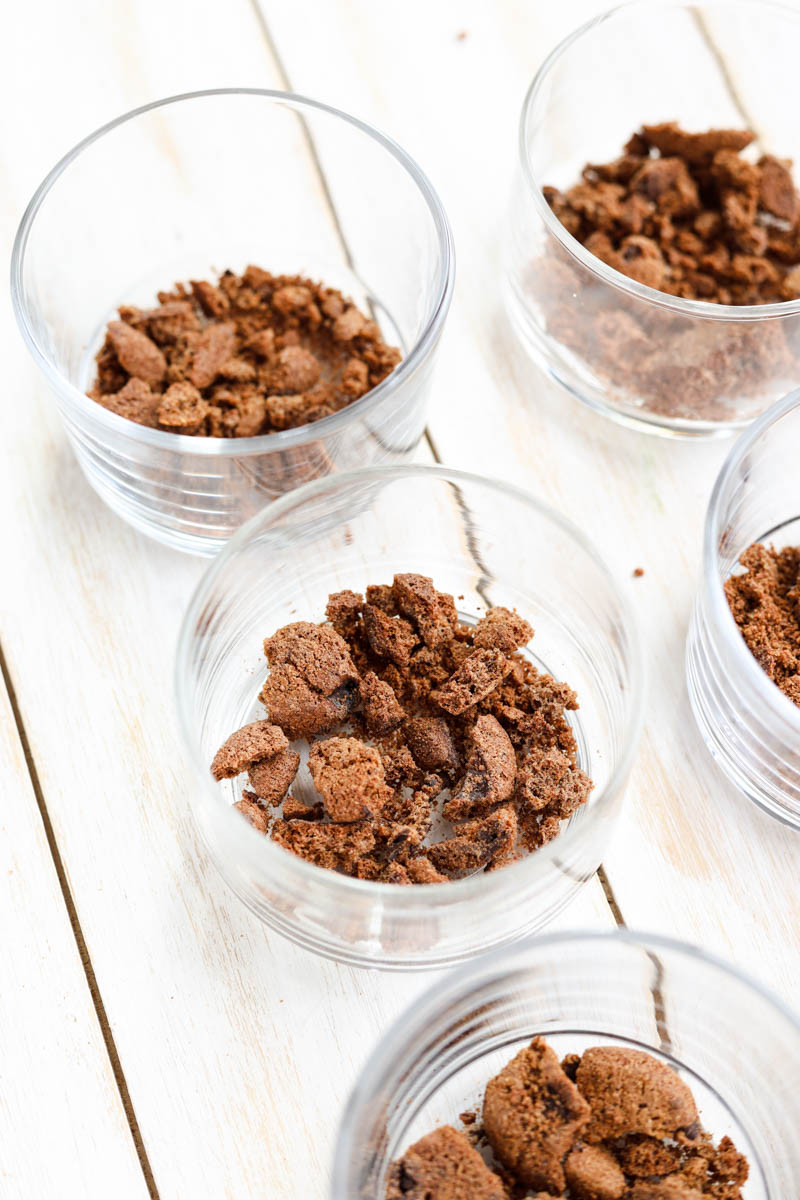 Cookies at the bottom of mini glass cups.
