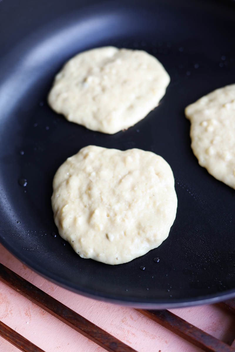 Pancakes cooking on skillet.