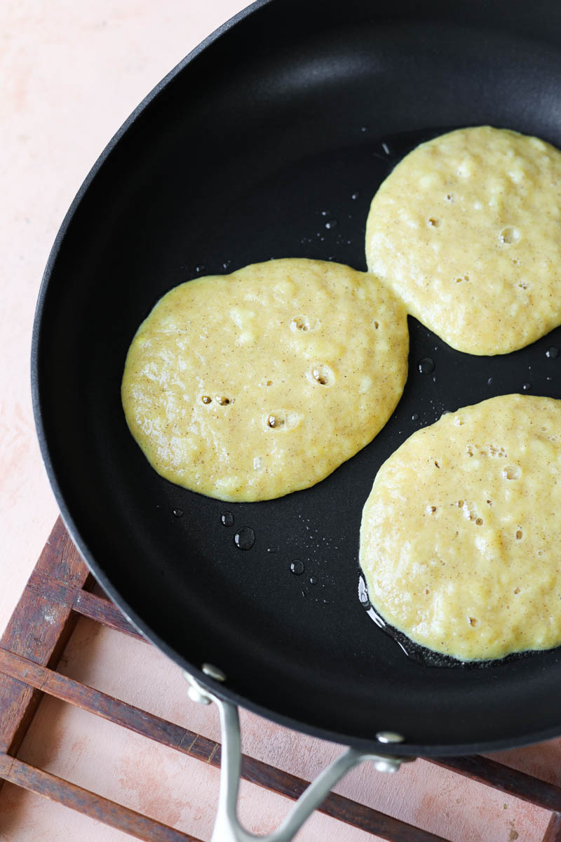 Pancakes cooking on skillet.