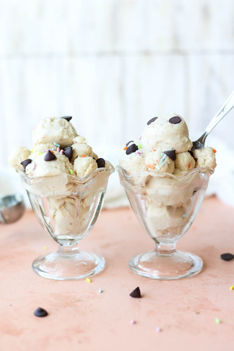 Two glass cups filled with scoops of cookie dough nice cream.