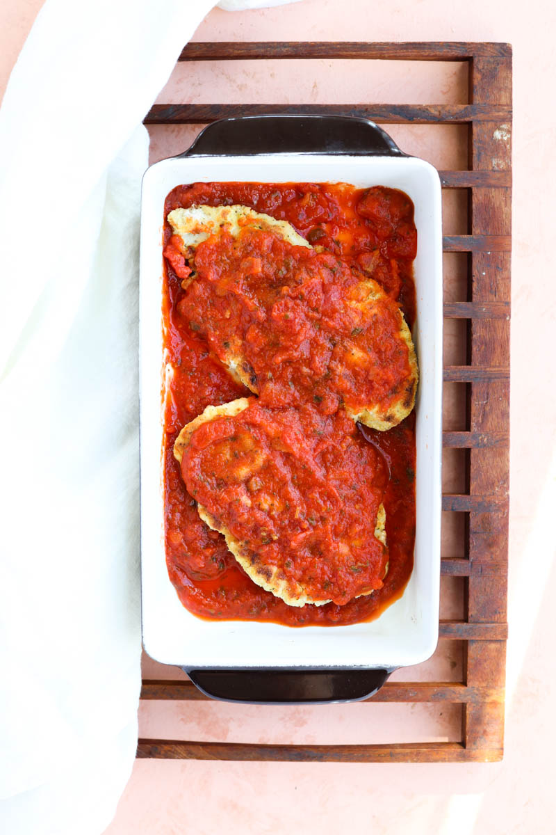 Chicken with sauce in a baking dish.