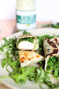 Pesto chicken wraps on a bed of arugula.