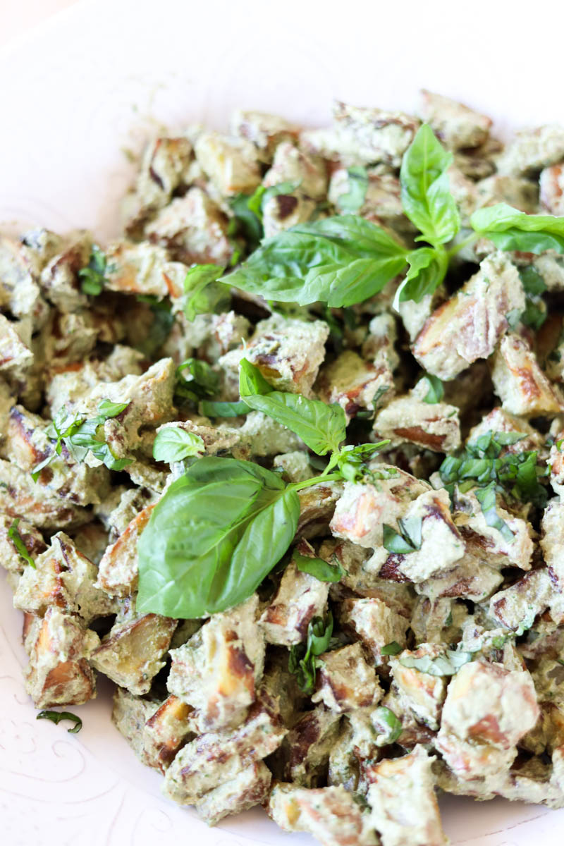 Roasted pesto potatoes with fresh basil leaves on top.