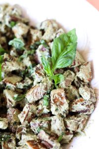 Roasted pesto potatoes in a white bowl.
