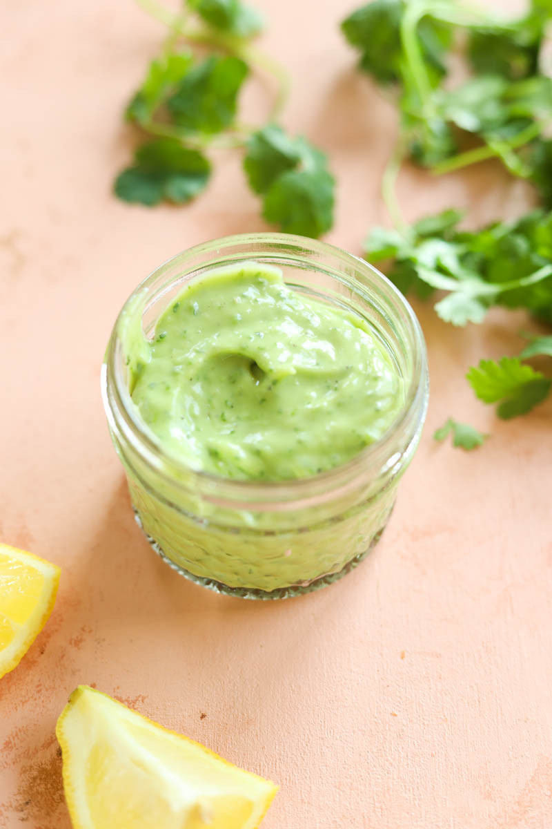 Mini mason jar filled with creamy avocado dressing.