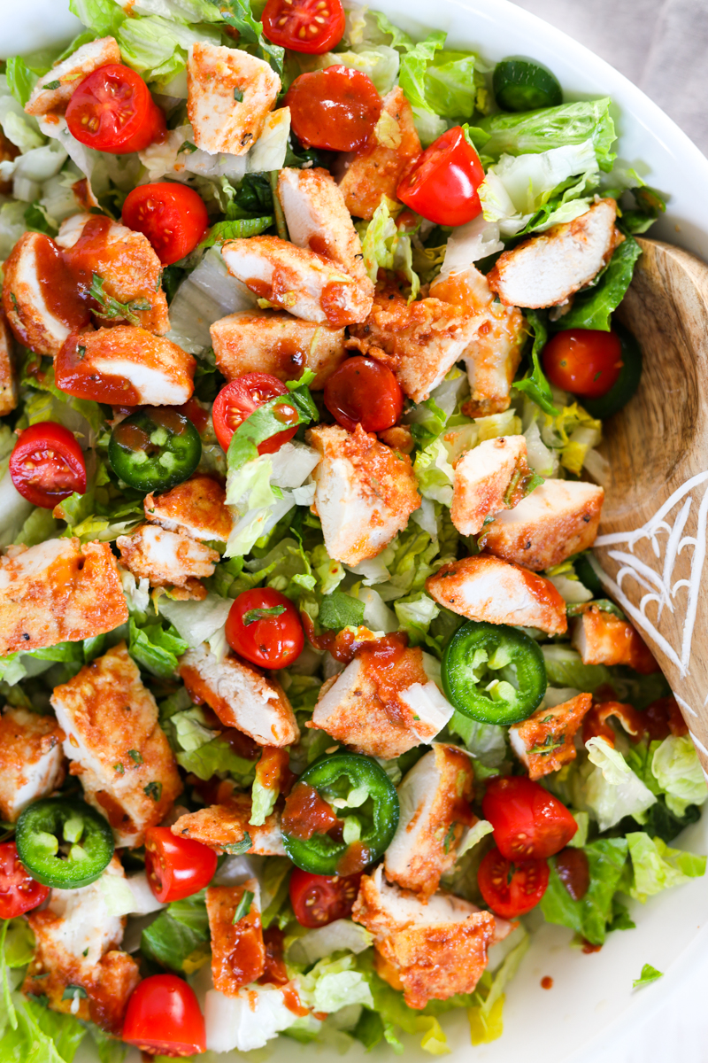 Wooden spoon scooping out bbq chicken salad