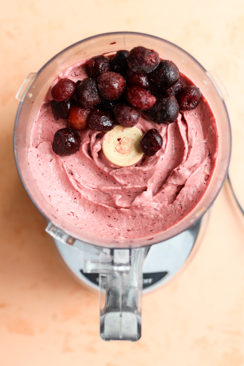 Cherries on top of ice cream in food processor.