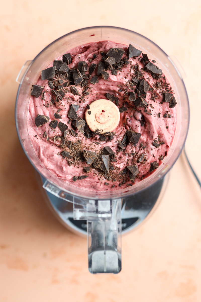 Chopped chocolate on top of nice cream in food processor.