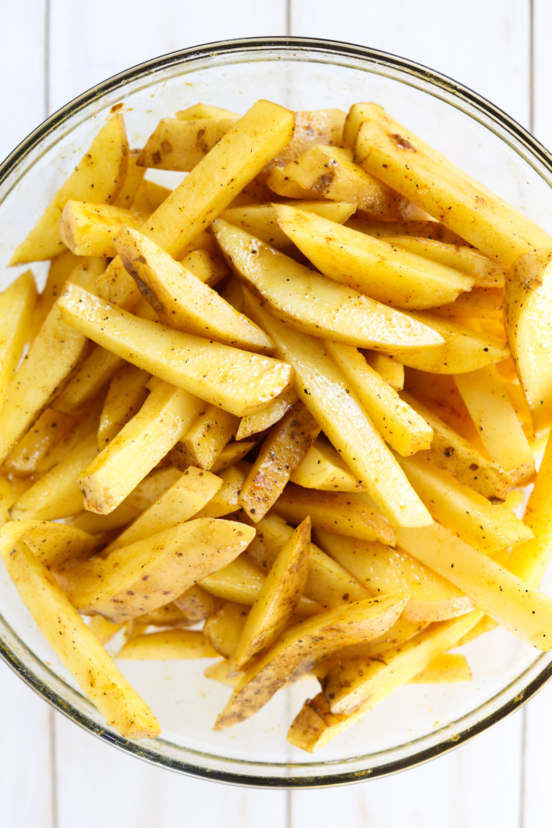 Potatoes seasoned in a glass bowl.
