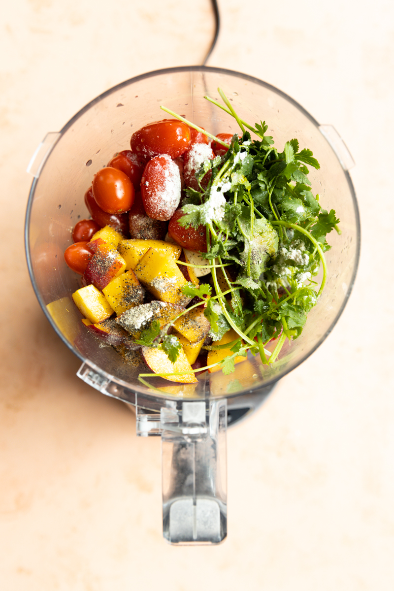 Peach salsa ingredients in a food processor.