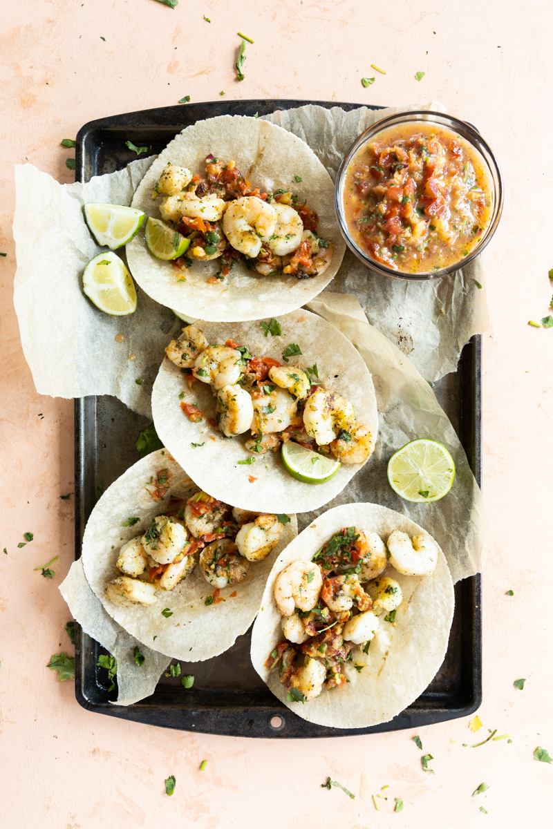 Grilled shrimp tacos on a try with parchment paper.