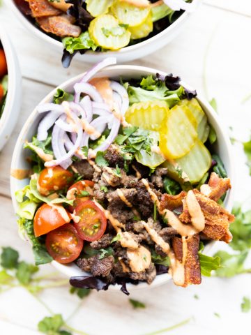 Close up picture of burger bowl with sauce drizzled overrtop.