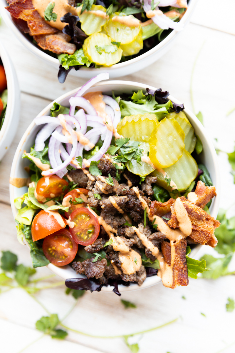 Close up picture of burger bowl with sauce drizzled overrtop.