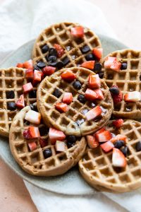 Mini waffles with chopped strawberries and chocolate chips.