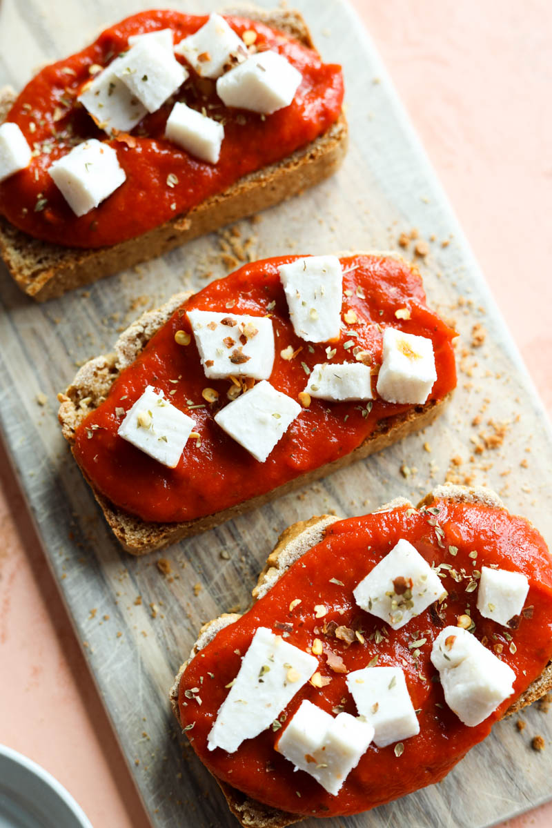Pizza toast on wooden board ready to be baked.