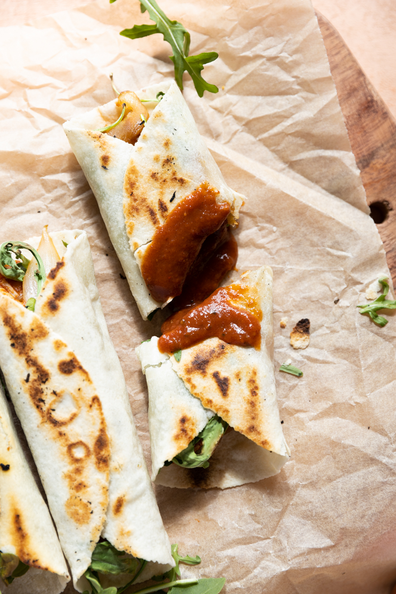 BBQ chicken wraps laying on parchment paper.